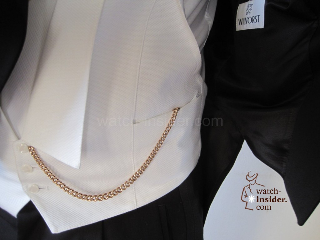 Pocket replica watch with its key chain is attached to the white vest of the tailcoat. Picture found @ uhrforum.de